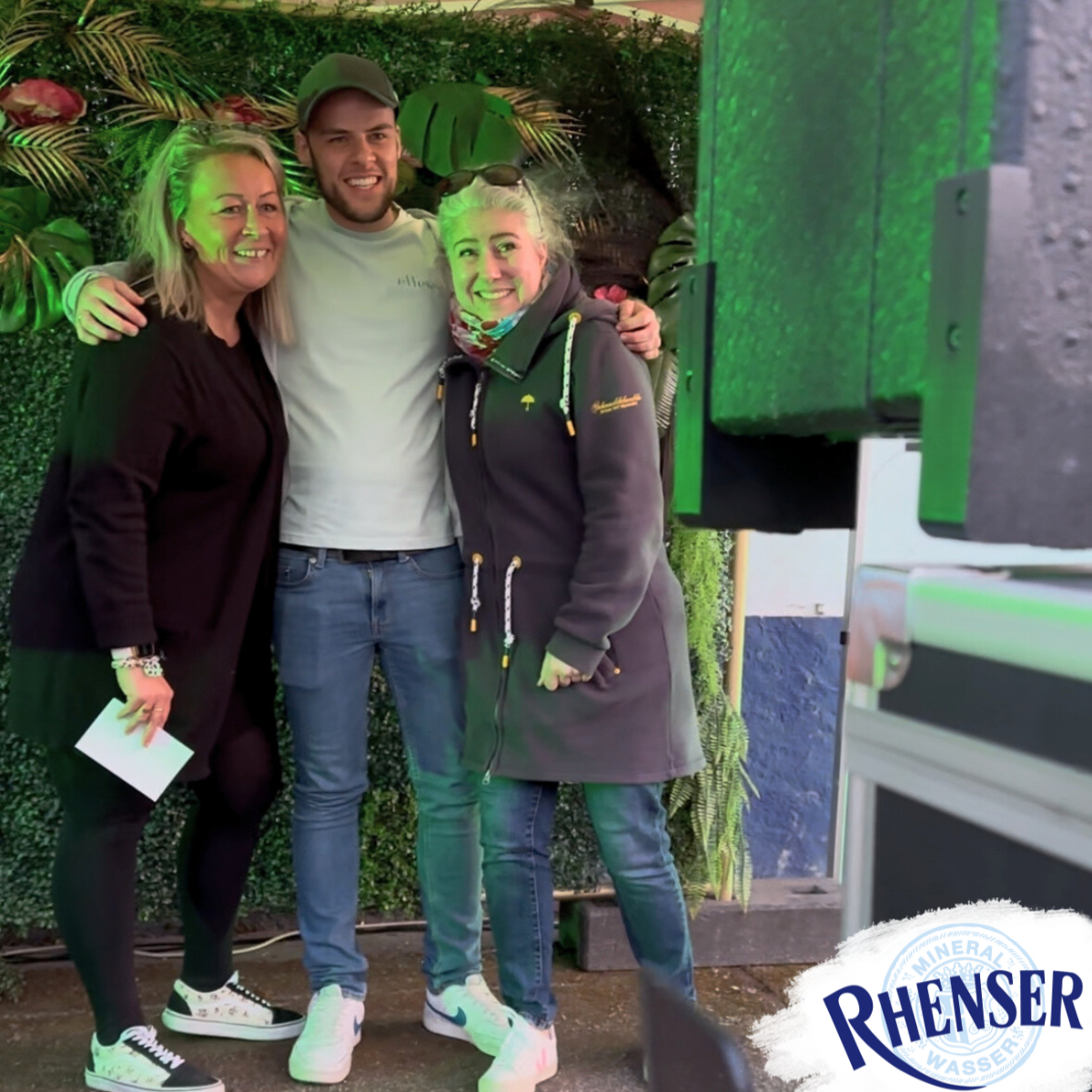 Drei Mitarbeitende des Rhenser Mineralbrunnens in Fotobox bei Rhenser Frühjahrsfest 2025.