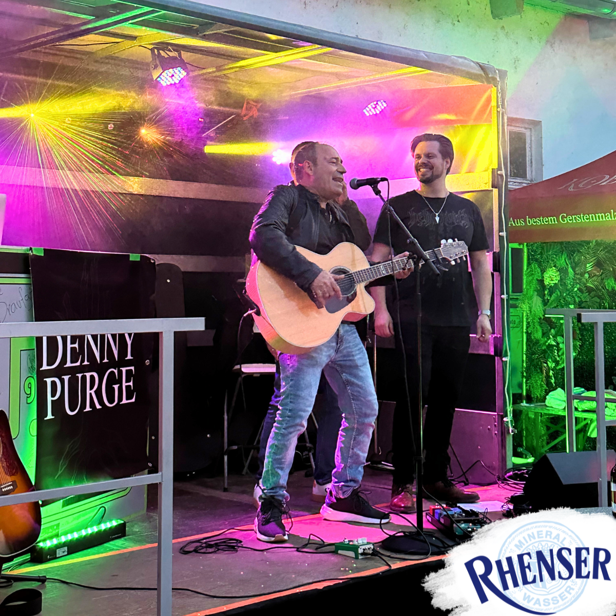 Rhenser-Mitarbeiter mit Gitarre auf Bühne beim Rhenser Frühjahrsfest 2025.