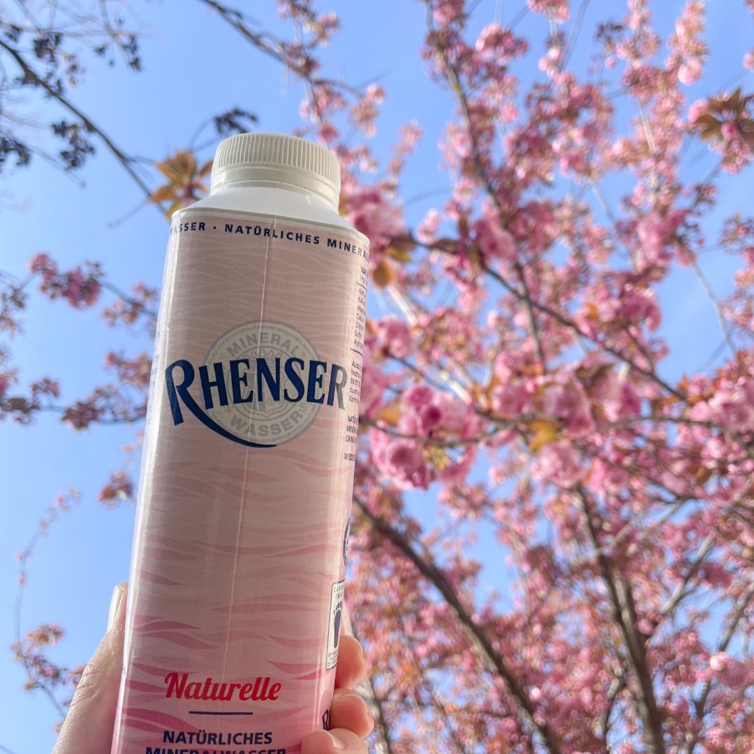 Rhenser Mineralwasser Naturelle in der 0,5l-Tetra-Top-Kartonverpackung vor Kirschblüten.