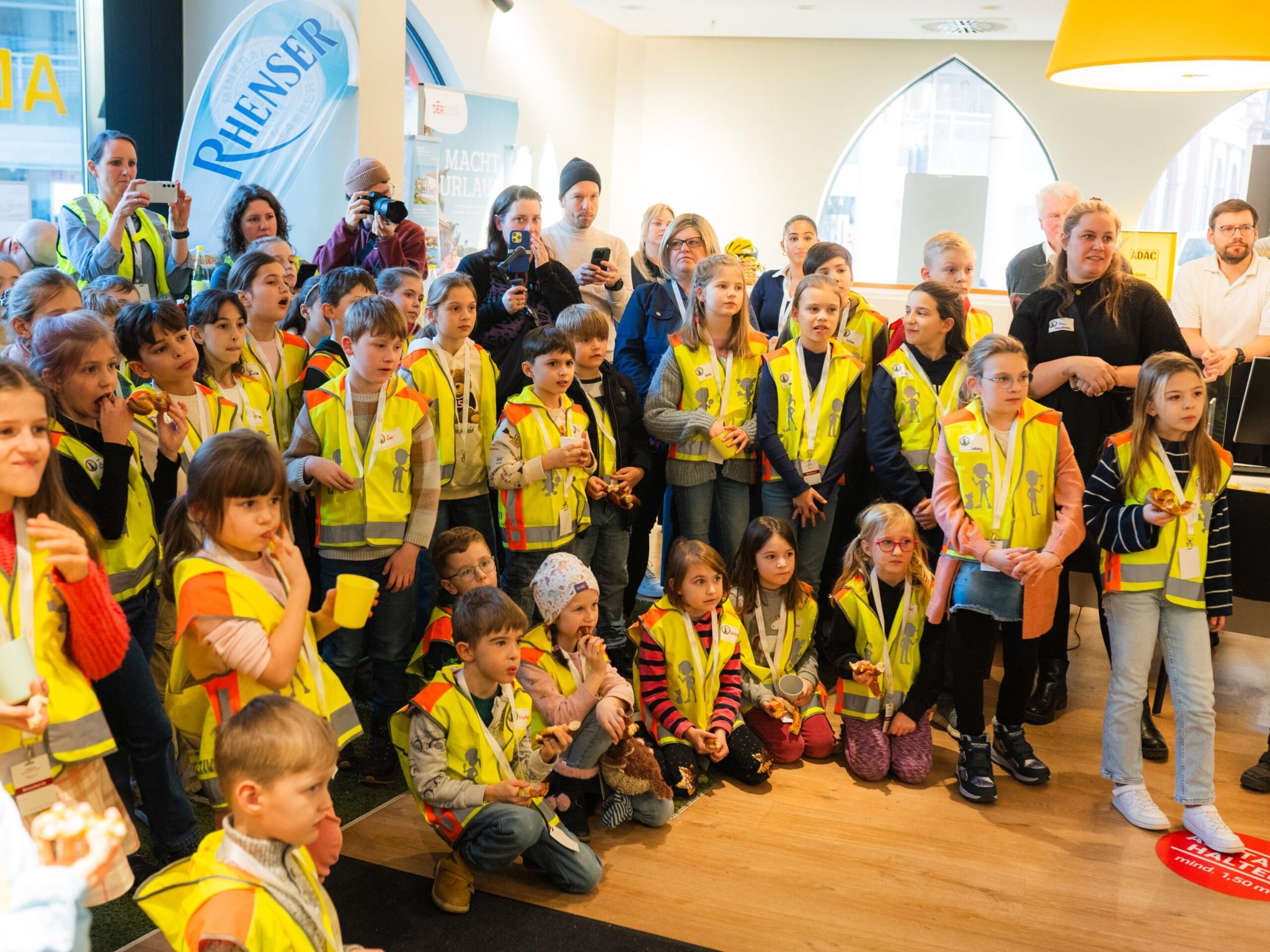 Schülerinnen und Schüler hören in den gewonnenen ADAC-Warnwesten gespannt den Rednern zu.