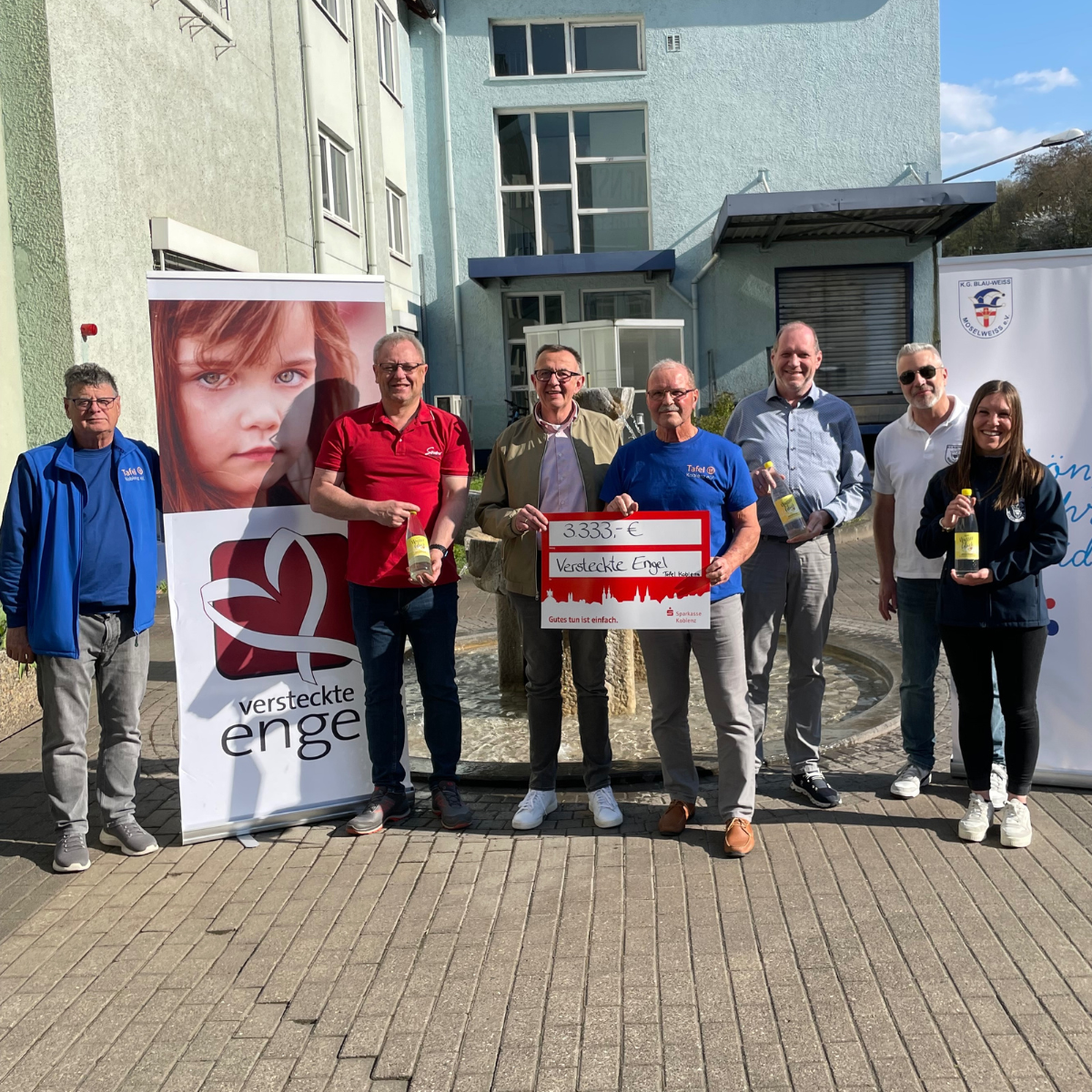 Rhenser-Geschäftsführer Christian Berentzen, AKK-Präsident Andreas Münch und das Koblenzer Tollitätenpaar 2025 überreichen Spendenscheck in Höhe von 3.333. Euro an die "Versteckten Engel" der Tafel Koblenz vor dem Rhenser Mineralbrunnen.