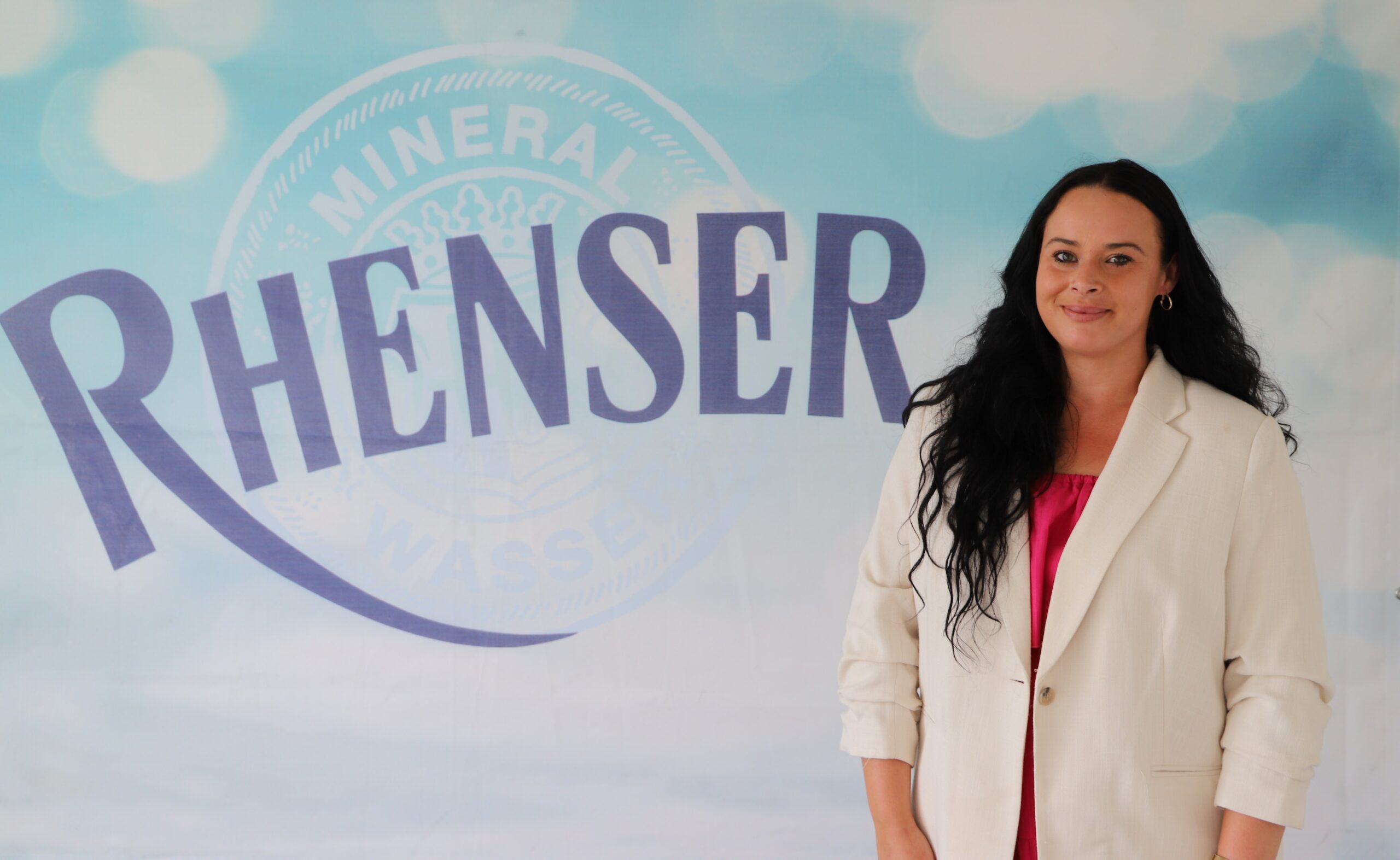 Porträtbild von Michelle Kadur, die vor Rhenser-Banner steht.