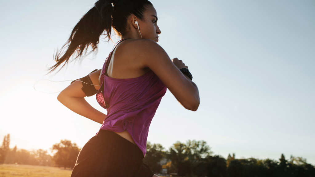 Läuferin beim Joggen im Freien mit Sportkleidung und Kopfhörern.